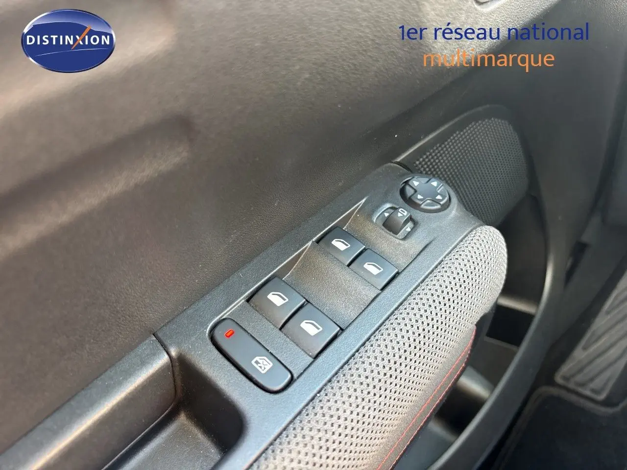 Gros plan sur les commandes des vitres électriques et rétroviseurs côté conducteur d'une Citroën C3 Aircross noir perla metal.