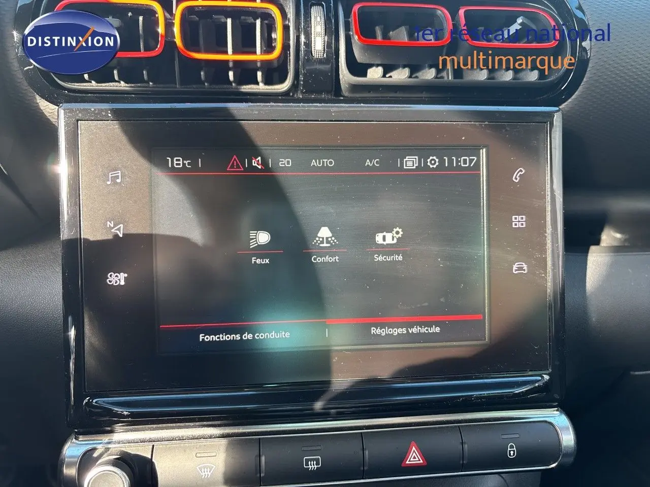 Vue rapprochée de l’écran tactile central et des aérateurs avec contours rouges dans l’habitacle noir du Citroën C3 Aircross 2019.
