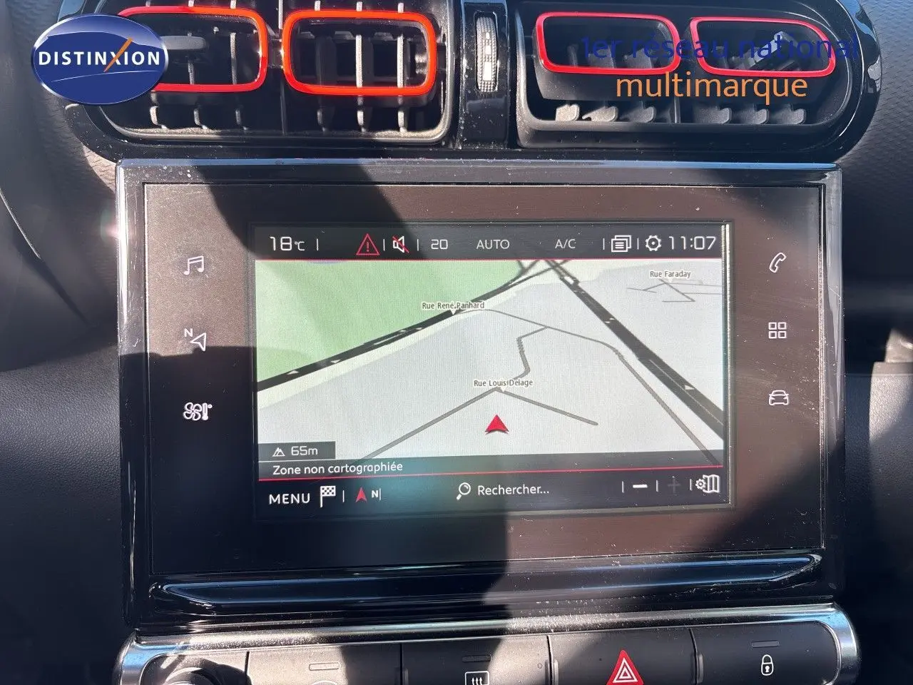 Vue rapprochée de l’écran tactile central avec navigation et aérateurs noirs et rouges du tableau de bord d’une Citroën C3 Aircross.