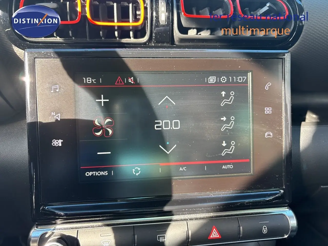 Gros plan sur l’écran tactile central de la Citroën C3 Aircross noir, affichant la climatisation à 20°C avec aérateurs rouges.