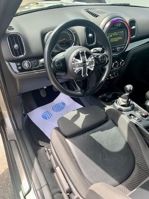 Vue intérieure côté conducteur du MINI Countryman Cooper D 150ch 2017 gris, volant Union Jack et boîte manuelle visible.