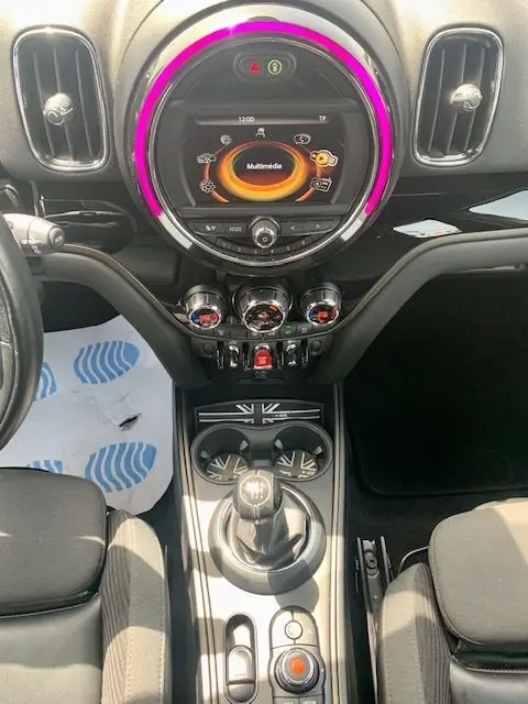 Tableau de bord intérieur de MINI Countryman Cooper D 2017, avec écran multimédia circulaire et éclairage violet autour.