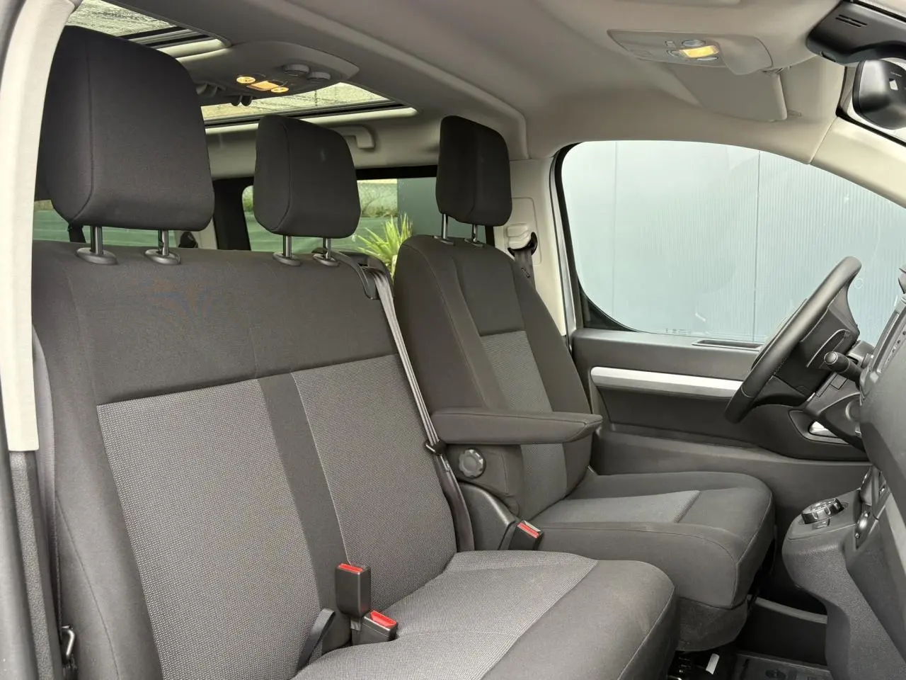 Intérieur avant de l'Opel Zafira Life XL gris, vue côté droit sur sièges tissu et toit panoramique lumineux.