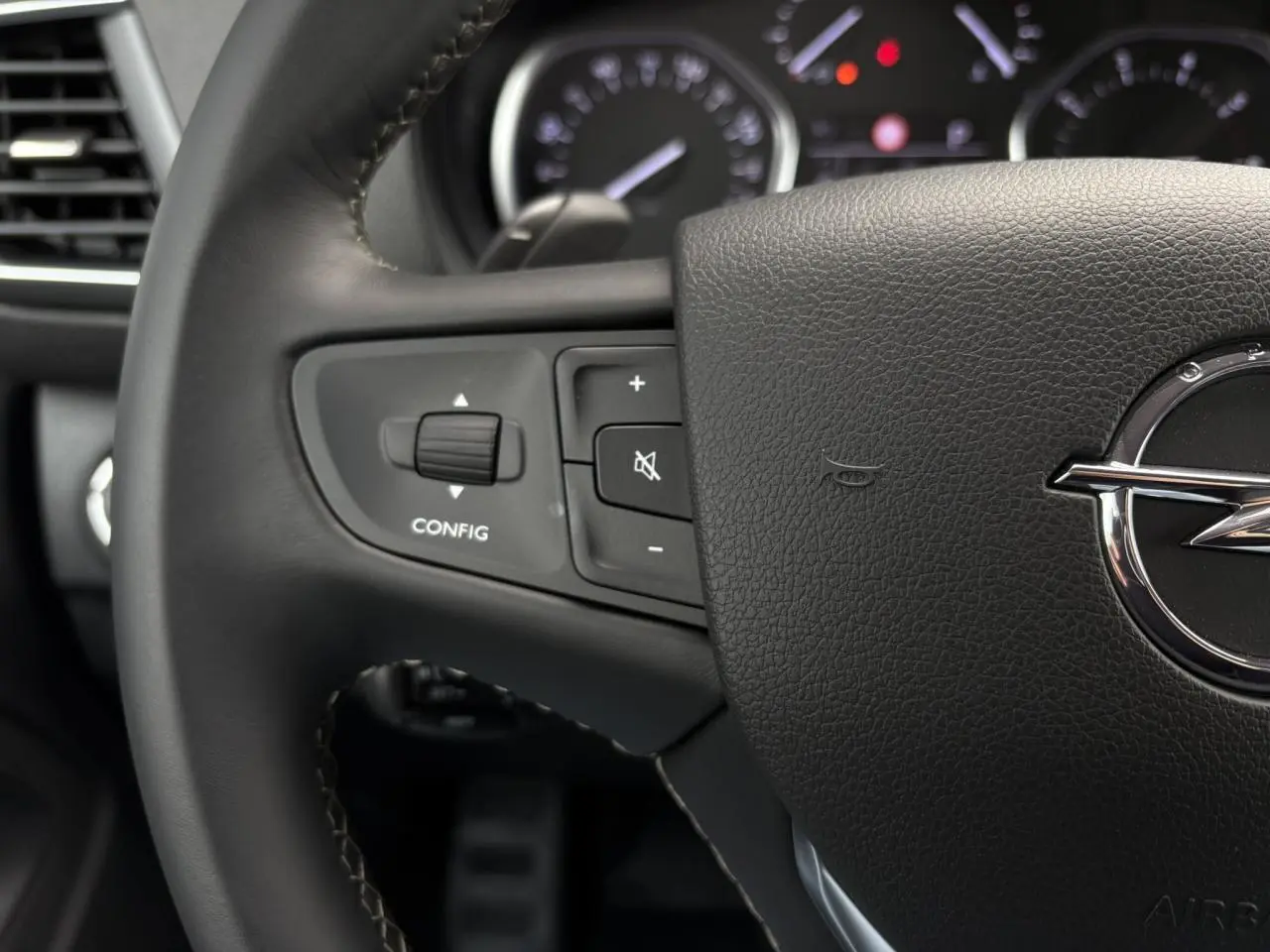 Gros plan sur le volant en cuir noir d'une Opel Zafira Life XL avec commandes intégrées et logo Opel visible.