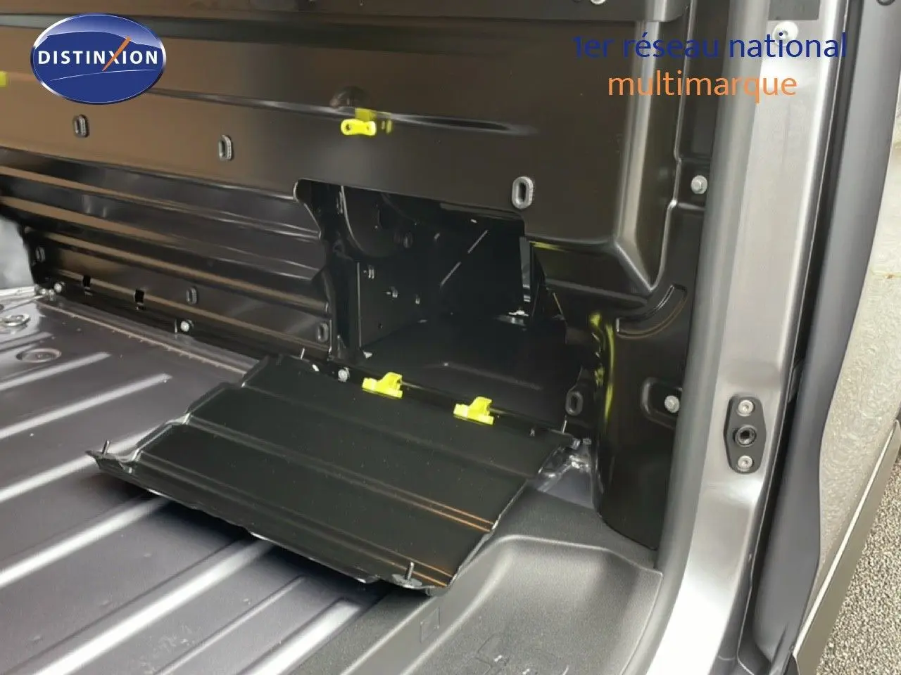 Vue intérieure du coffre du Citroën Jumpy gris Artense, mettant en valeur un compartiment de rangement ouvert sur le côté droit.