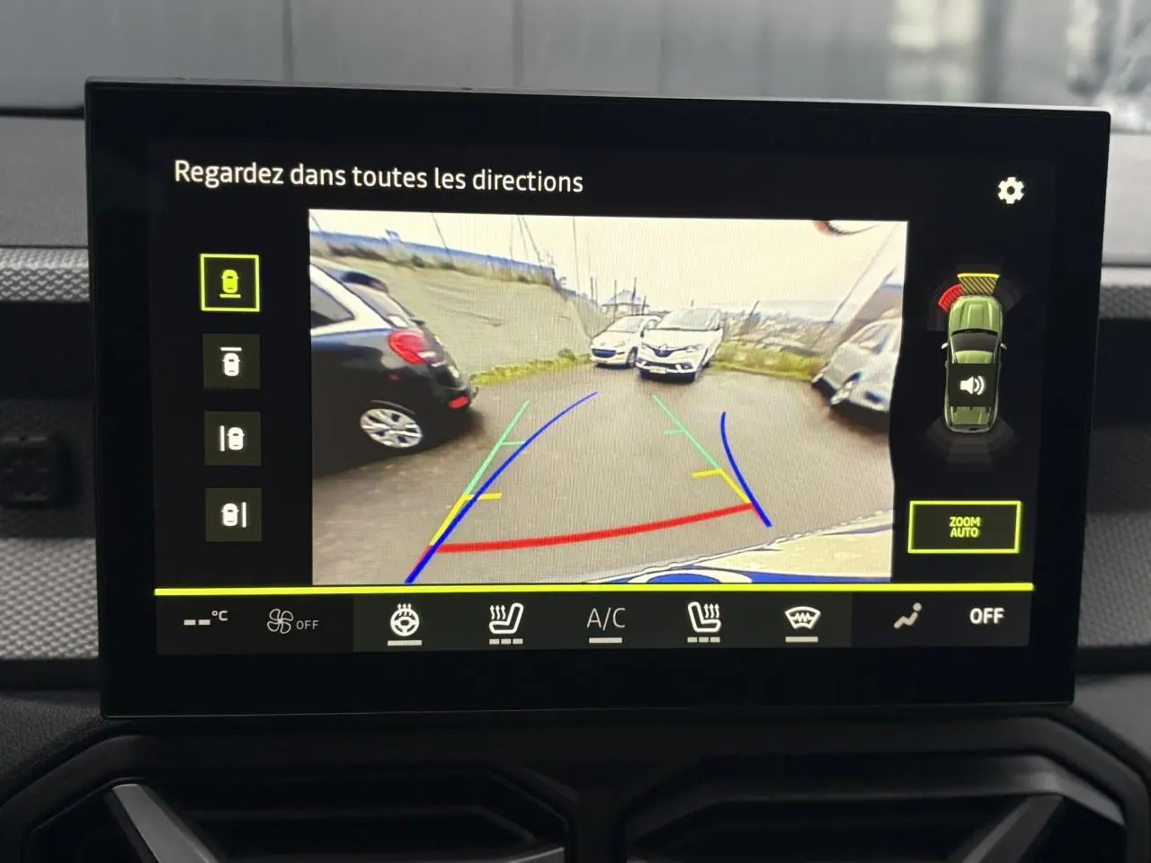 Écran tactile intérieur montrant la caméra 360° du Dacia Duster gris schiste en marche arrière avec guidage de trajectoire.