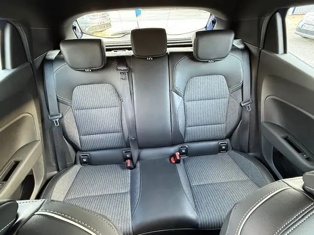 Vue intérieure arrière de la Renault Clio V 1.3 TCE 140 Intens 2022, sièges tissu gris et cuir noir avec appuie-têtes.