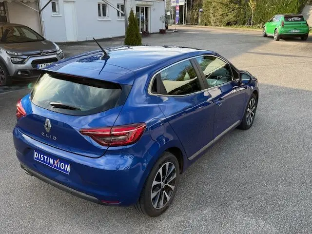 Vue 3/4 arrière droite d'une Renault Clio V 1.3 TCE 140 Intens bleu Iron avec jantes alliage et vitres teintées.