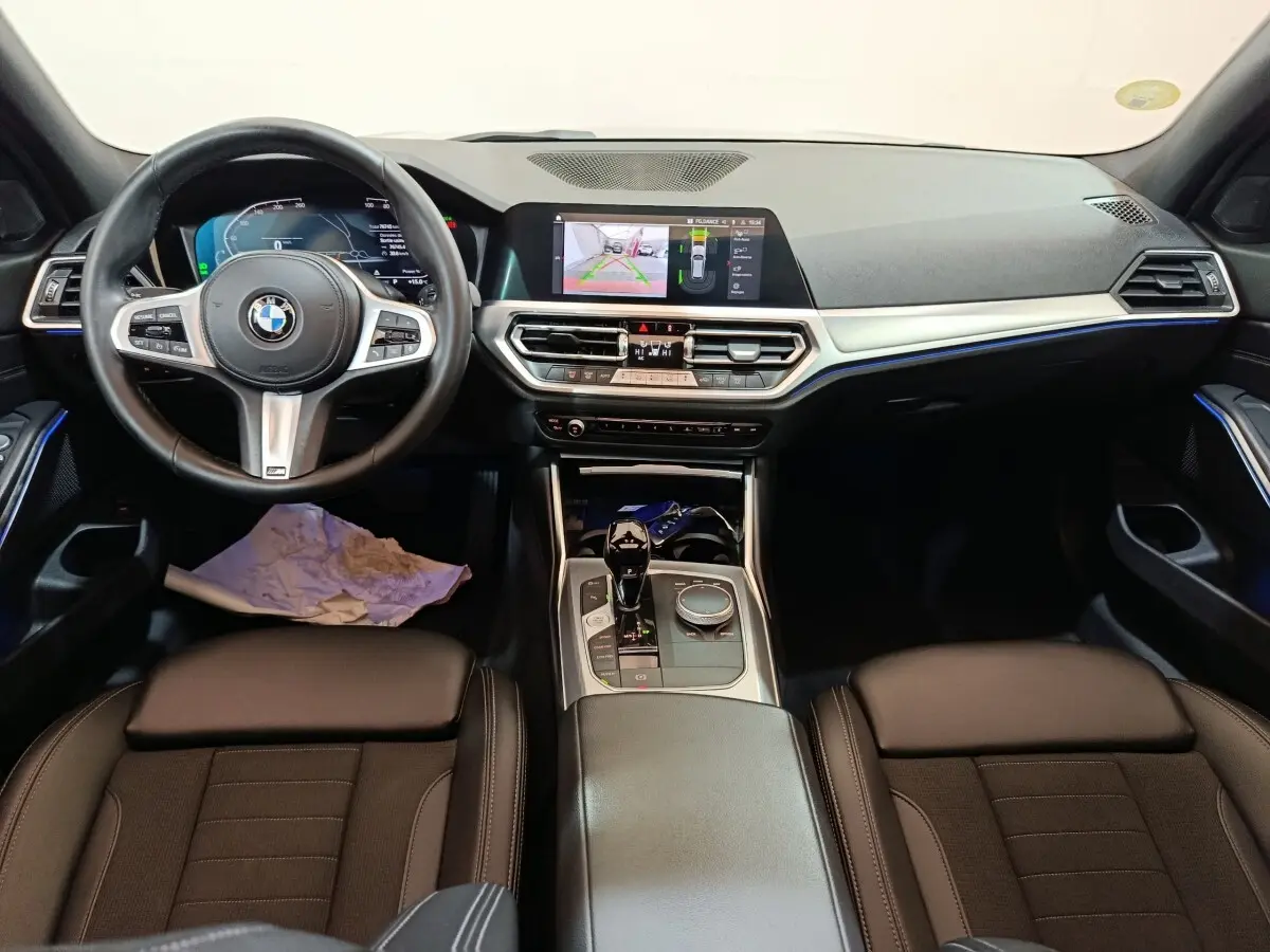 Intérieur BMW Série 3 318d 2022 vu de face, tableau de bord noir avec écran tactile central et volant cuir multifonctions.