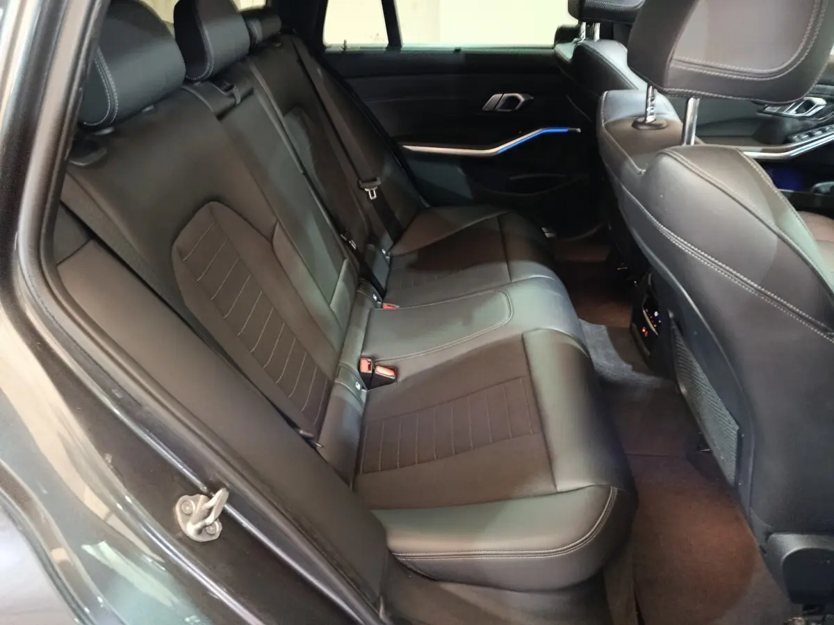 Vue intérieure côté droit sur la banquette arrière en cuir noir de la BMW Série 3 318d Lounge 2022.