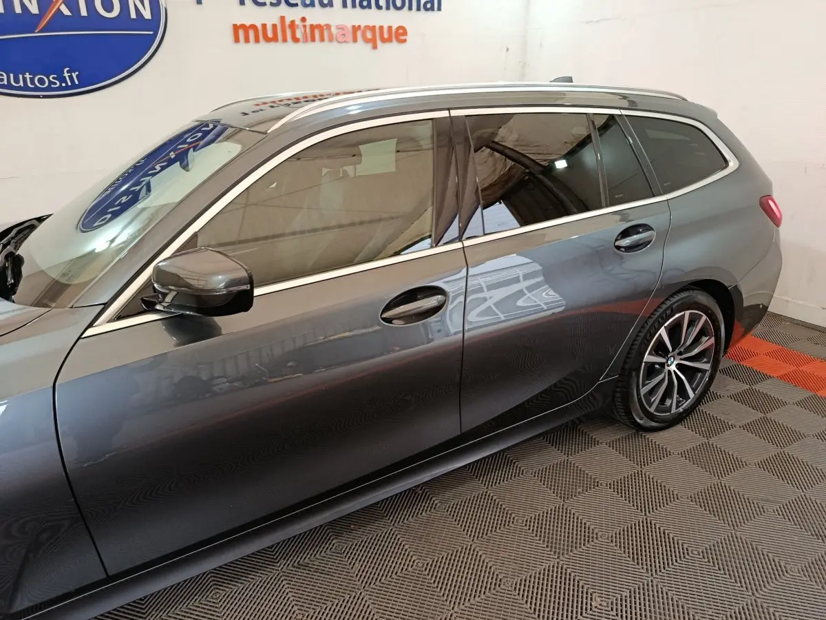 Vue de profil côté gauche d'une BMW Série 3 Touring gris clair avec jantes alliage et vitres teintées.