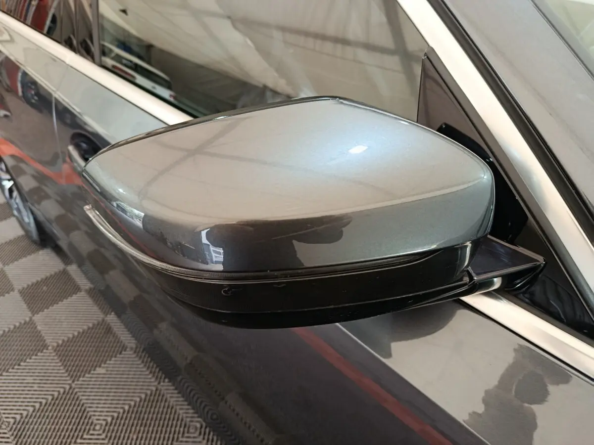 Rétroviseur droit gris clair de BMW Série 3 318d 2022, vue rapprochée avec carrosserie brillante et cadre chromé.