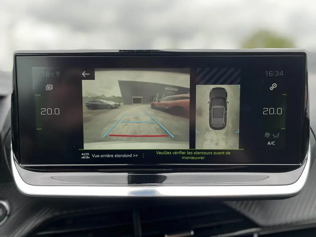 Écran tactile intérieur montrant la caméra de recul et l’aide au stationnement du Peugeot 2008 noir.