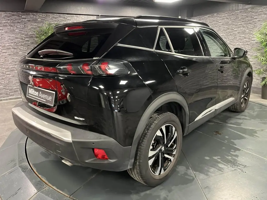 Peugeot 2008 noir perla nacré vue 3/4 arrière droit, jantes alliage bi-tons et feux arrière LED griffés.