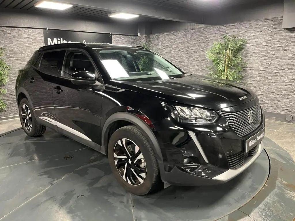 Peugeot 2008 noir perla nacré vue 3/4 avant droit en intérieur avec jantes alliage bi-ton et calandre chromée.