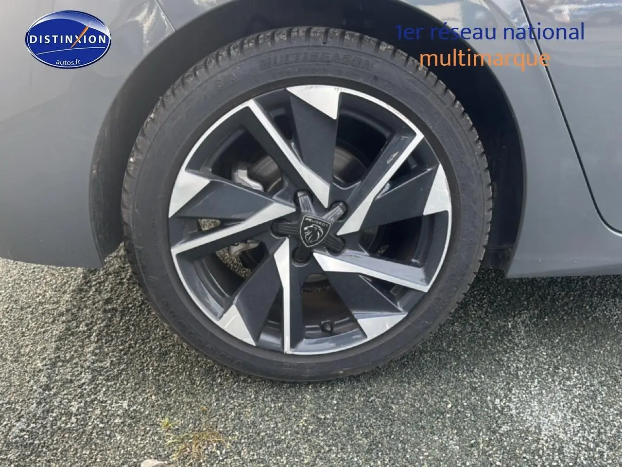 Gros plan sur la jante alu noire et argentée du côté arrière droit d'une Peugeot 308 gris sélénite.