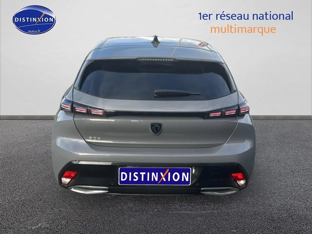 Vue arrière d'une Peugeot 308 gris sélénite 2024 avec feux arrière LED et double sortie d'échappement chromée.
