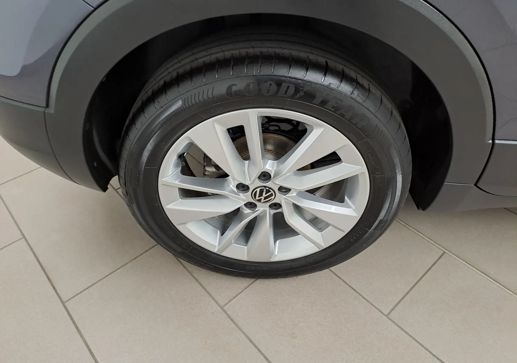 Gros plan sur la roue avant droite du Volkswagen T-Cross gris cendré avec jante alliage et pneu Goodyear.