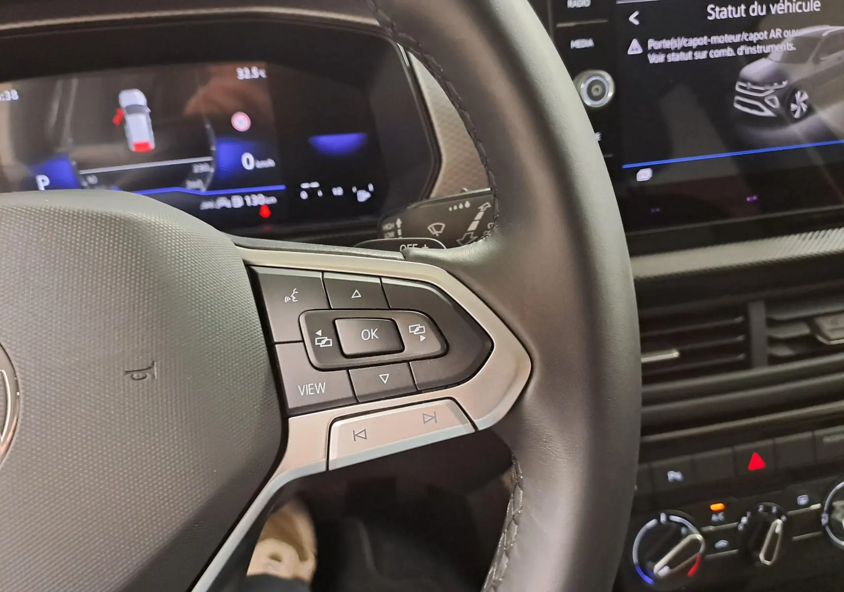 Gros plan sur le volant côté gauche et tableau de bord numérique du Volkswagen T-Cross gris cendré 2025, version VW Edition.