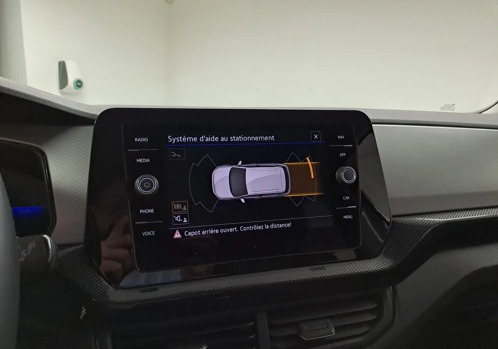 Écran tactile du système d'aide au stationnement dans un Volkswagen T-Cross 2025, tableau de bord noir.