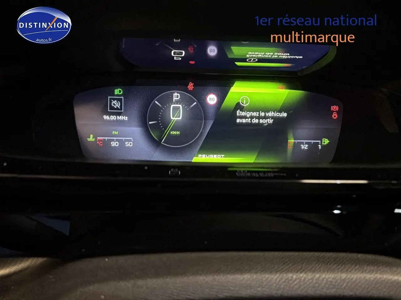 Tableau de bord numérique éclairé de la Peugeot 408 Hybrid gris sélénite, affichage vitesse et alertes au centre.