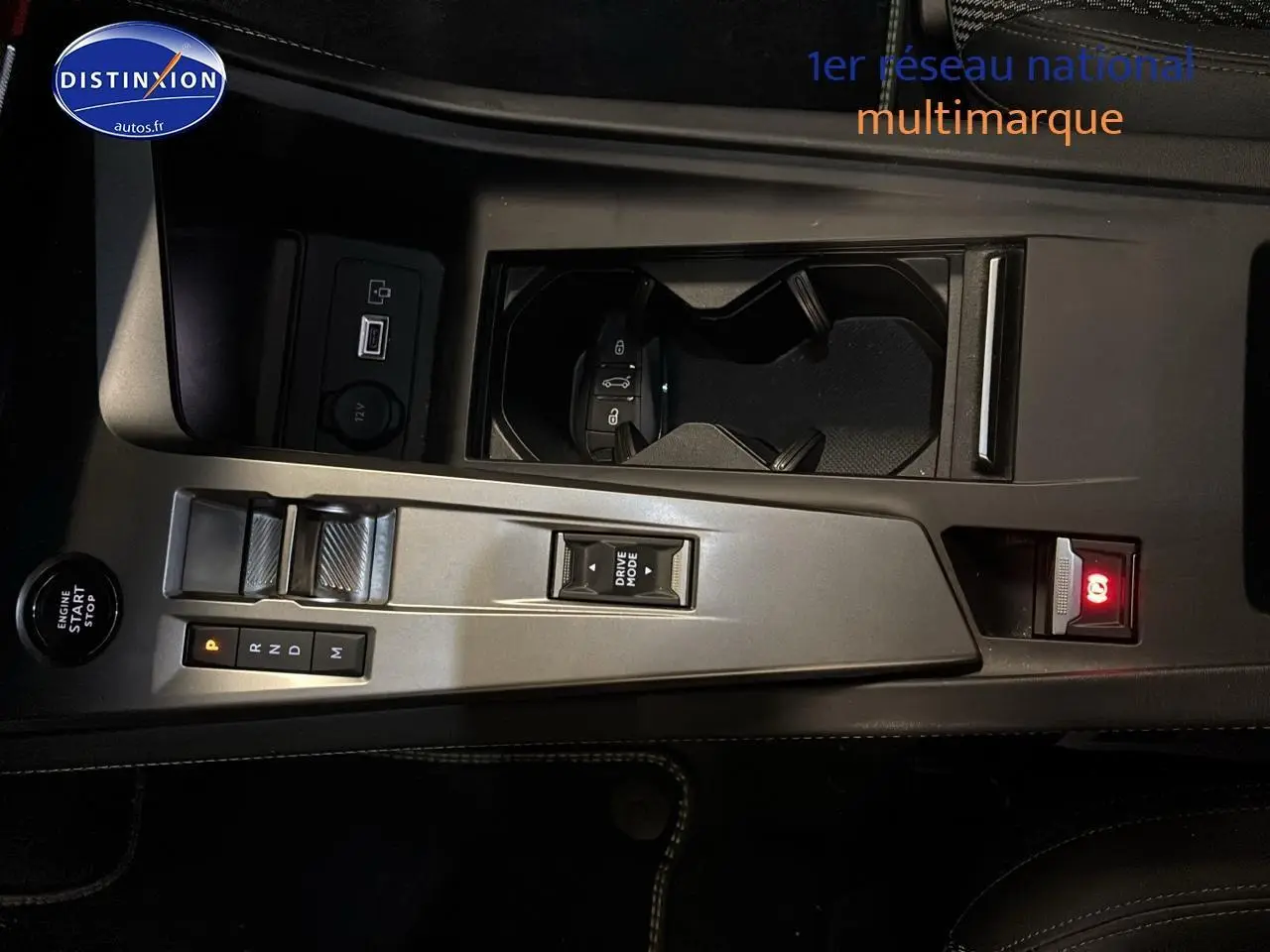 Vue rapprochée de la console centrale grise du Peugeot 408 Hybrid 145 GT avec levier de vitesses automatique et bouton start/stop.