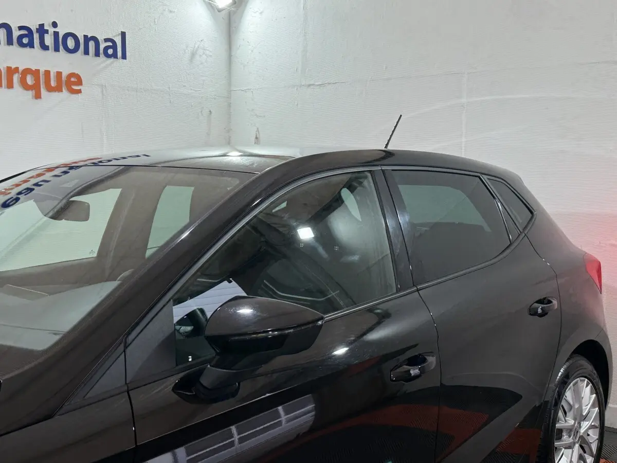 Vue latérale droite d'une SEAT Ibiza noire 2024, mettant en valeur les vitres teintées et les jantes alliage.
