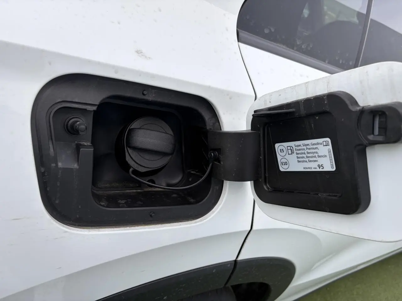 Gros plan sur la trappe à carburant côté gauche d'un Volkswagen T-Roc blanc pur avec toit noir, essence, 2026.