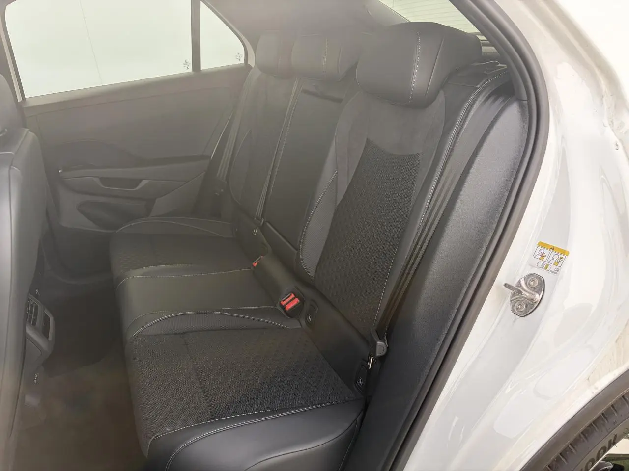 Vue côté droit sur la banquette arrière noire en tissu et cuir du Volkswagen T-Roc blanc toit noir 2026 R-Line.