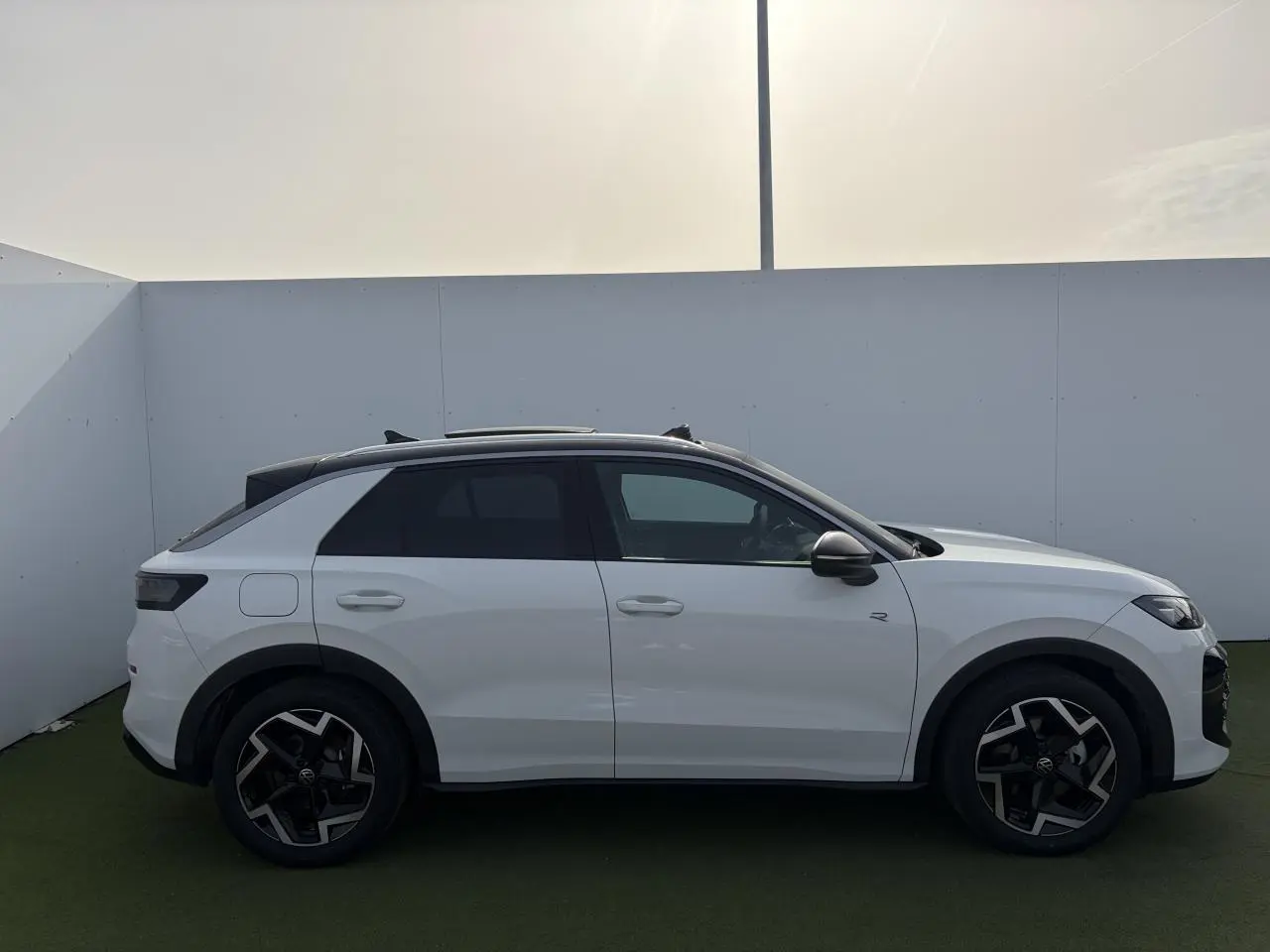 Profil droit du Volkswagen T-Roc blanc pur avec toit noir et jantes 18 pouces Coventry en extérieur.
