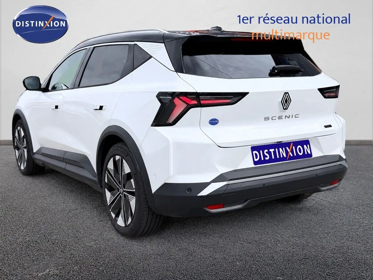 Vue 3/4 arrière droite du Renault Scénic 5 blanc 2024 électrique avec toit noir et feux arrière LED distinctifs.