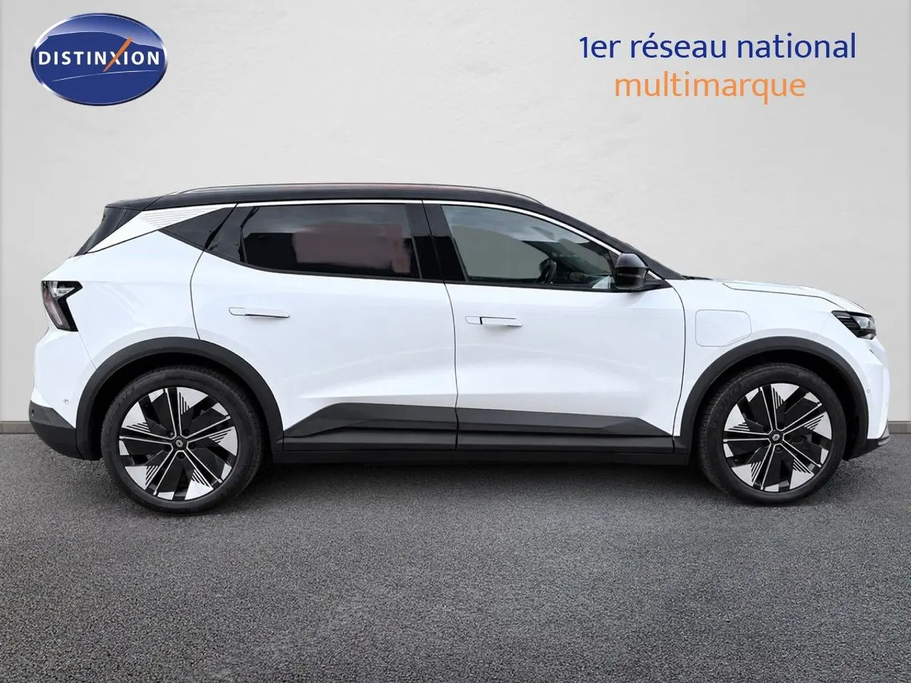 Profil droit du Renault Scenic 5 blanc 2024 électrique avec toit noir et jantes noires à motifs géométriques.