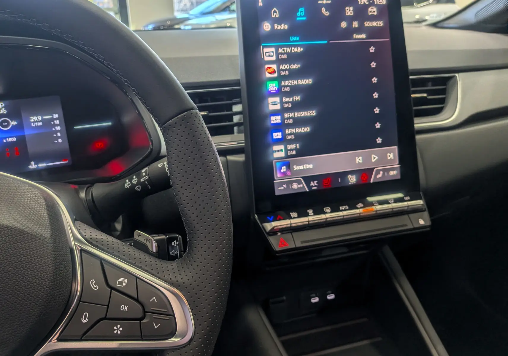 Intérieur du Renault Captur 2025 Mild Hybrid, vue sur le volant perforé et l'écran tactile central affichant la radio.