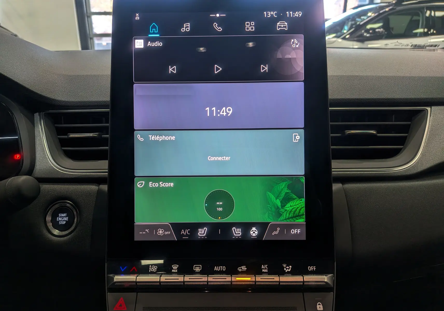 Vue rapprochée de l'écran tactile central du tableau de bord du Renault Captur gris rafale 2025, affichant les commandes multimédia et climatisation.