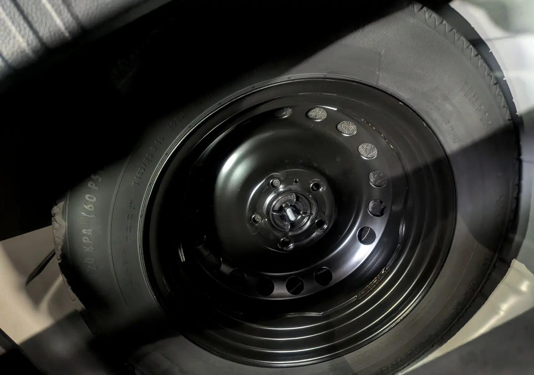 Gros plan sur la roue de secours noire en acier du Renault Captur Gris Rafale 2025, montrant le pneu et la jante simple.