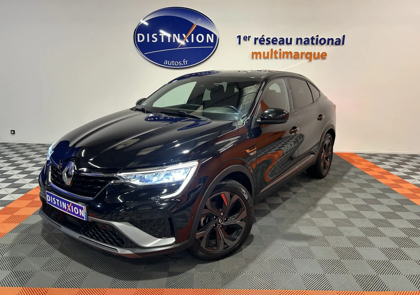 Renault Arkana E-Tech noir en 3/4 avant droit, avec phares allumés et jantes noires distinctives.