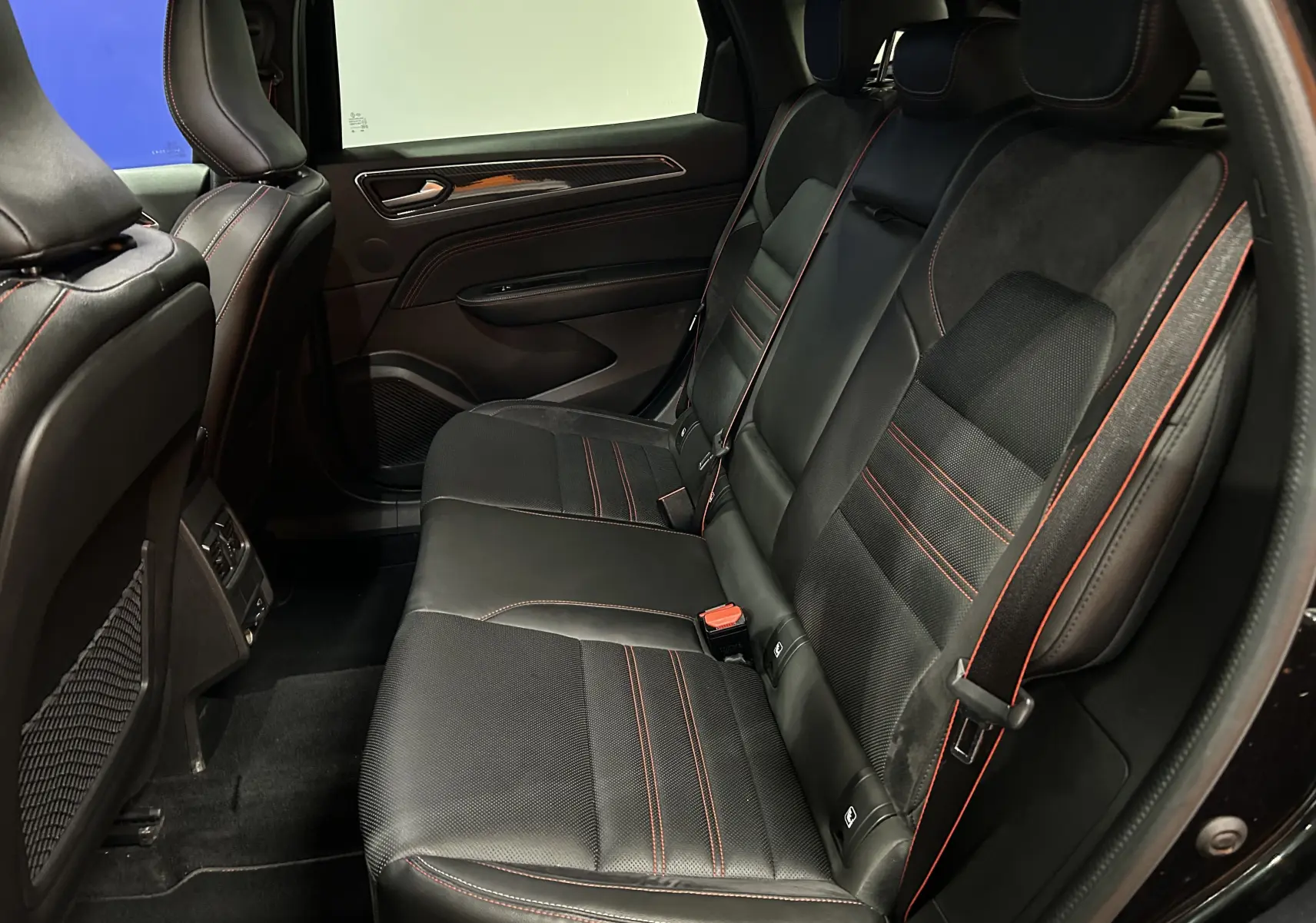 Vue intérieure côté droit des sièges arrière noirs avec surpiqûres rouges du Renault Arkana E-Tech 145ch RS Line 2022.