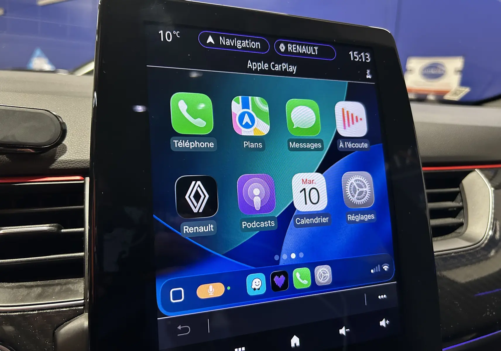 Écran tactile central de Renault Arkana E-Tech 2022 affichant Apple CarPlay avec interface colorée et détails de navigation.