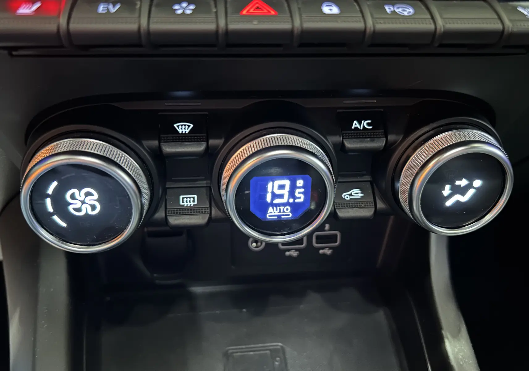 Détail de la console centrale du Renault Arkana noir, montrant les commandes de climatisation automatique à 19,5°C.