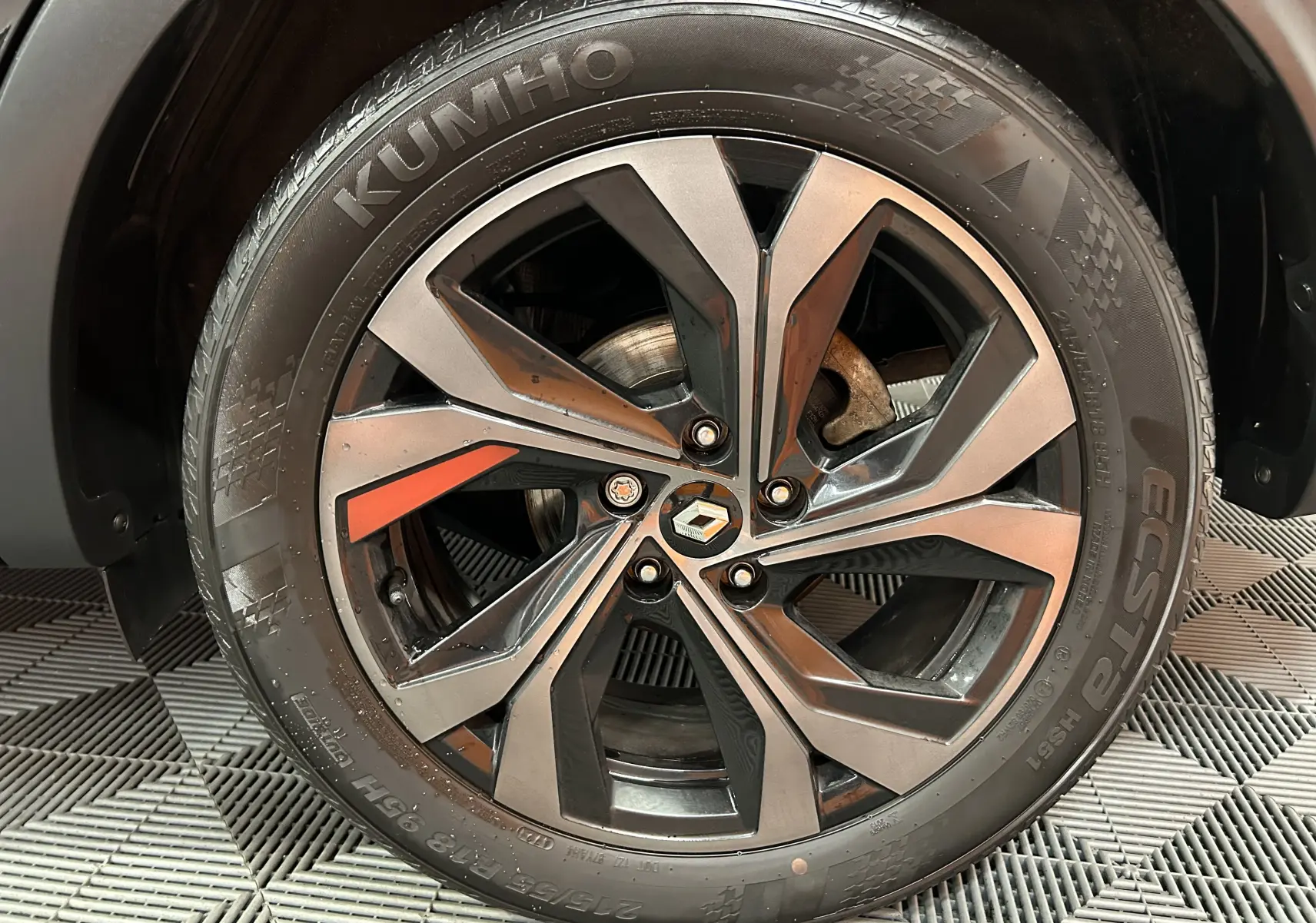 Gros plan sur la jante alliage noire et grise avec logo Renault au centre sur un pneu Kumho.