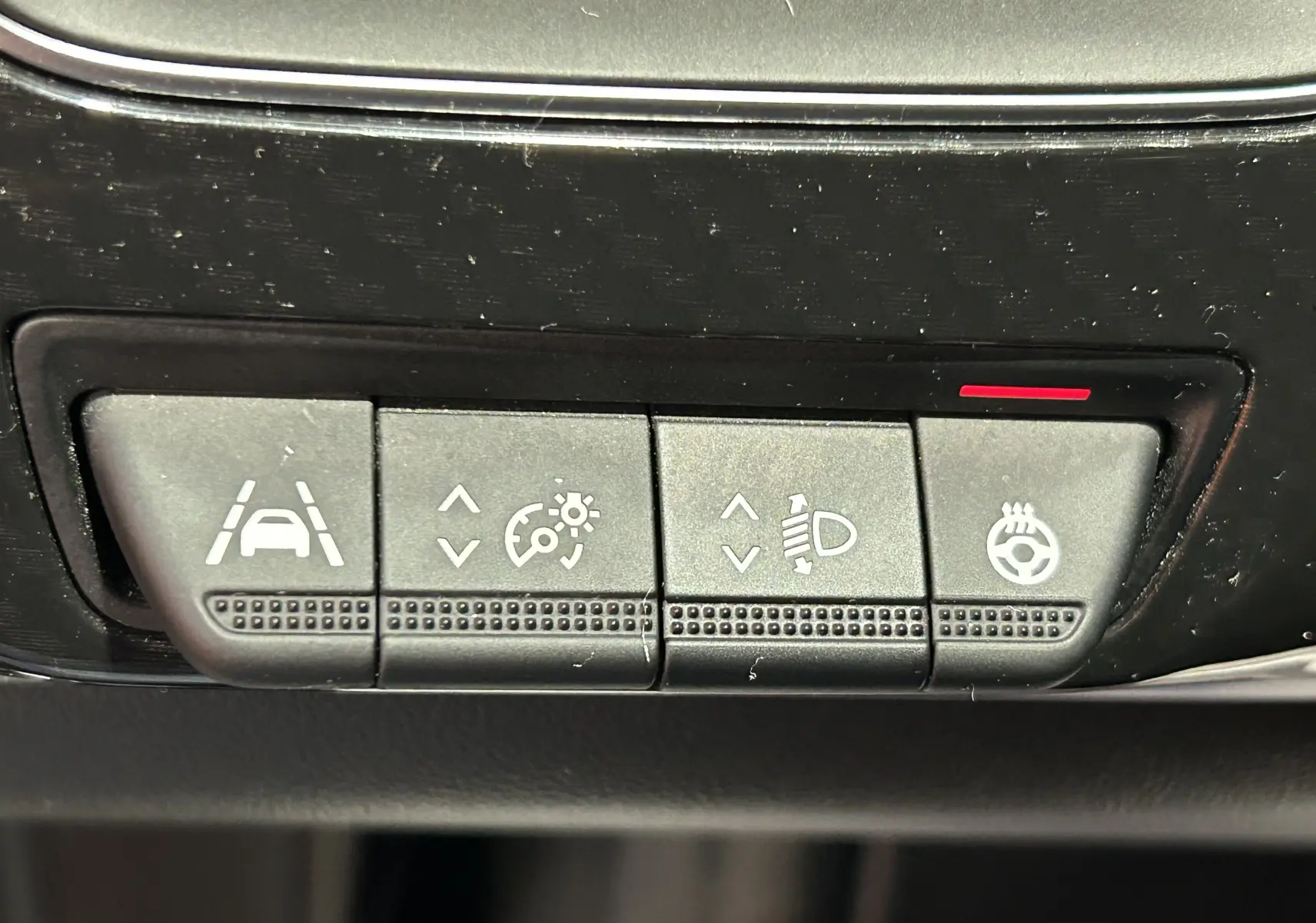 Gros plan sur les boutons de réglage d'assistance et de volant chauffant dans une Renault Arkana noire, version E-Tech 2022.