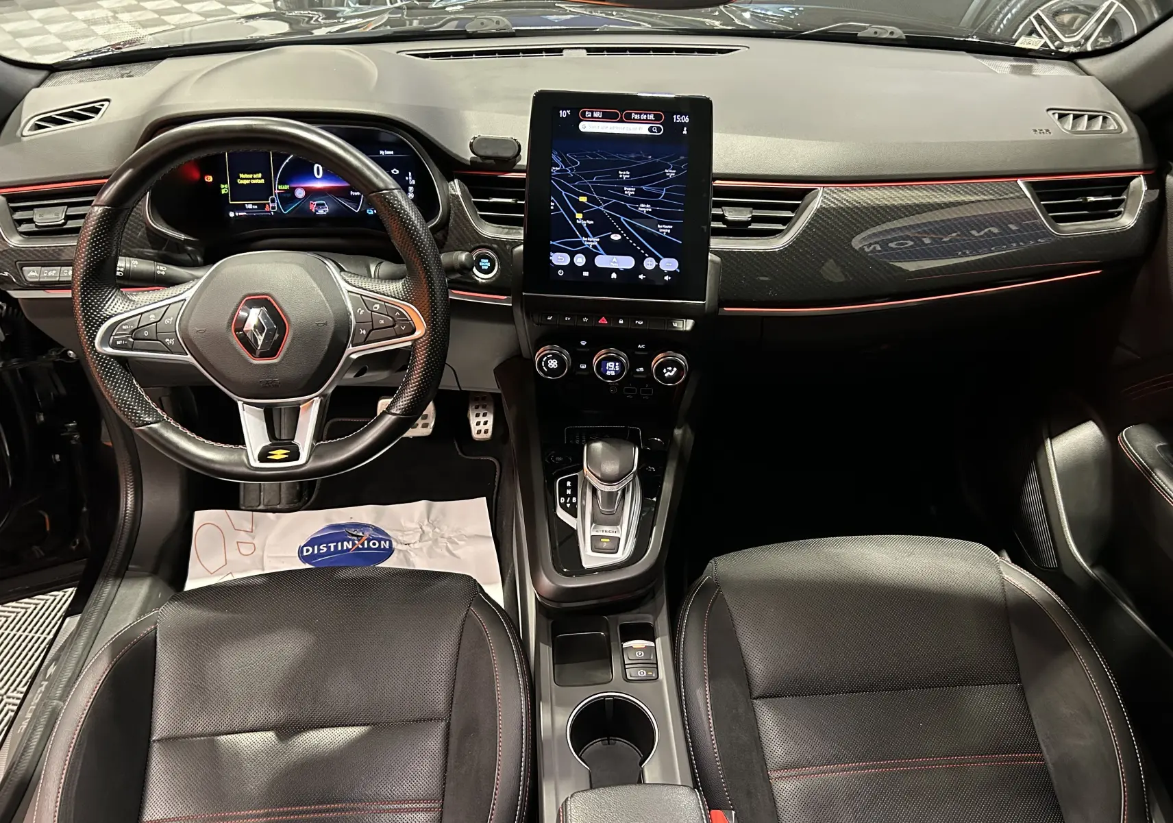 Vue intérieure avant du Renault Arkana noir E-Tech 145ch RS Line avec volant sport, écran tactile vertical et sièges cuir noirs.