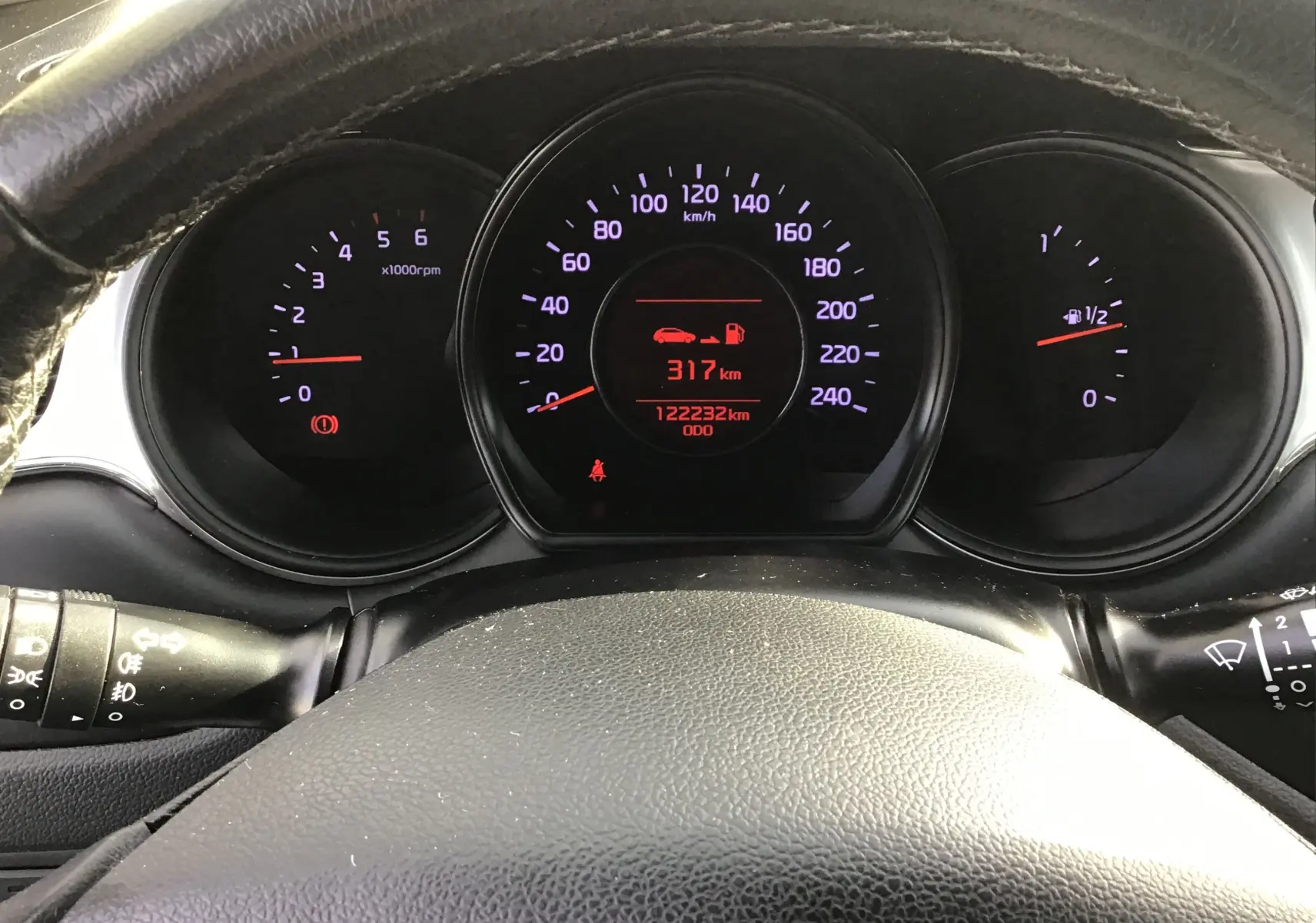 Vue rapprochée du tableau de bord noir de la Kia CEE'D SW 2017, affichant le compteur et l'odomètre à 122232 km.