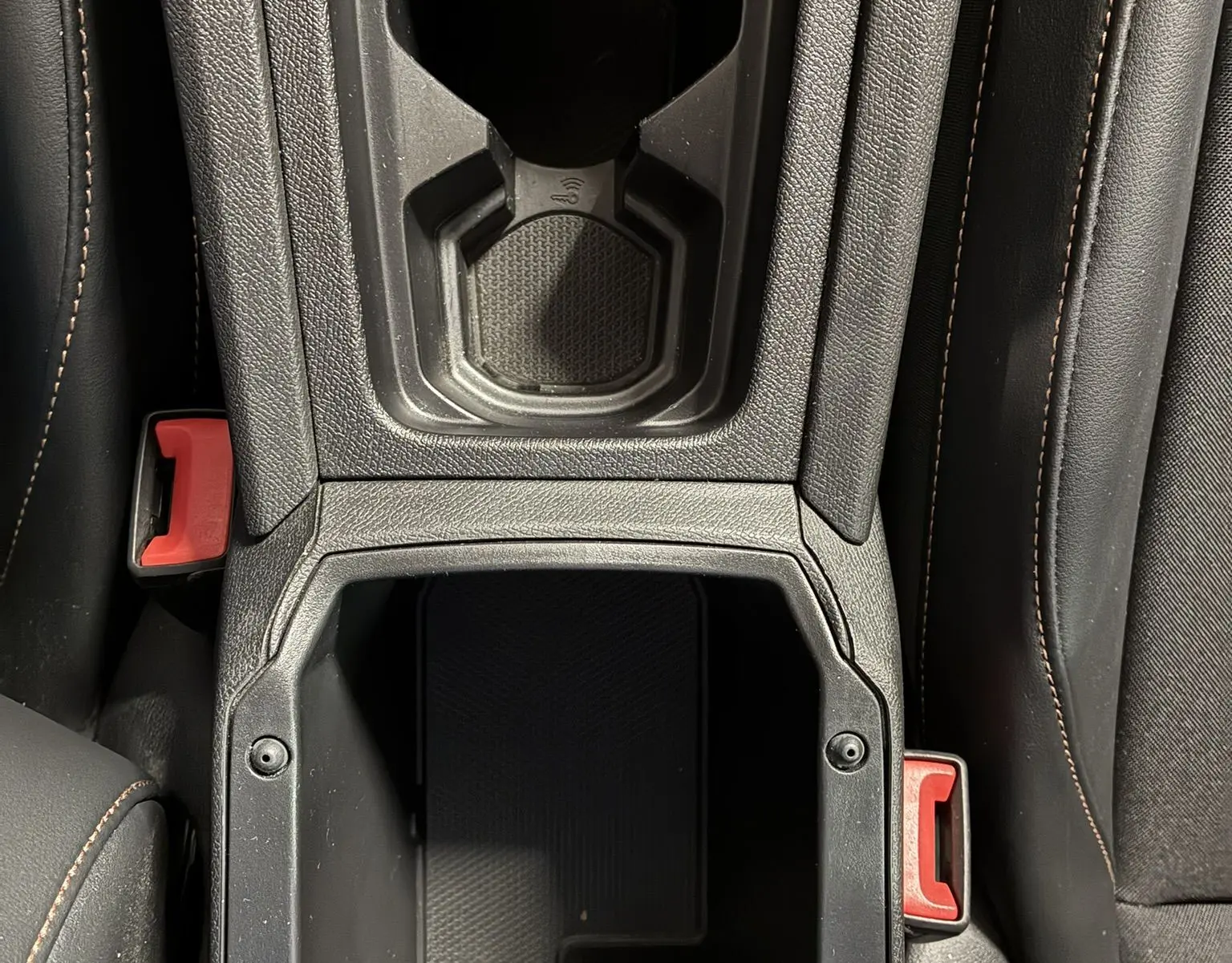 Vue plongeante sur la console centrale noire du CUPRA Formentor 1.4 E-HYBRID 2023, avec porte-gobelet et prise 12V visible.