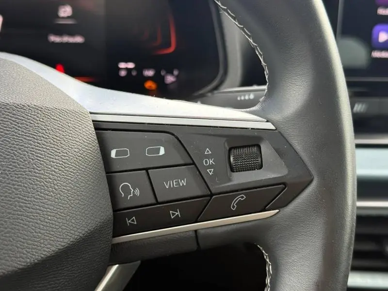 Gros plan sur les commandes multifonctions à droite du volant du SEAT Arona 2025, boutons noirs avec icônes blanches.