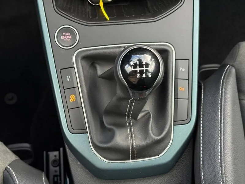 Gros plan sur le levier de vitesses manuel du SEAT Arona 2025 en Gris Magnétique Métal avec bouton Start/Stop et commandes autour.