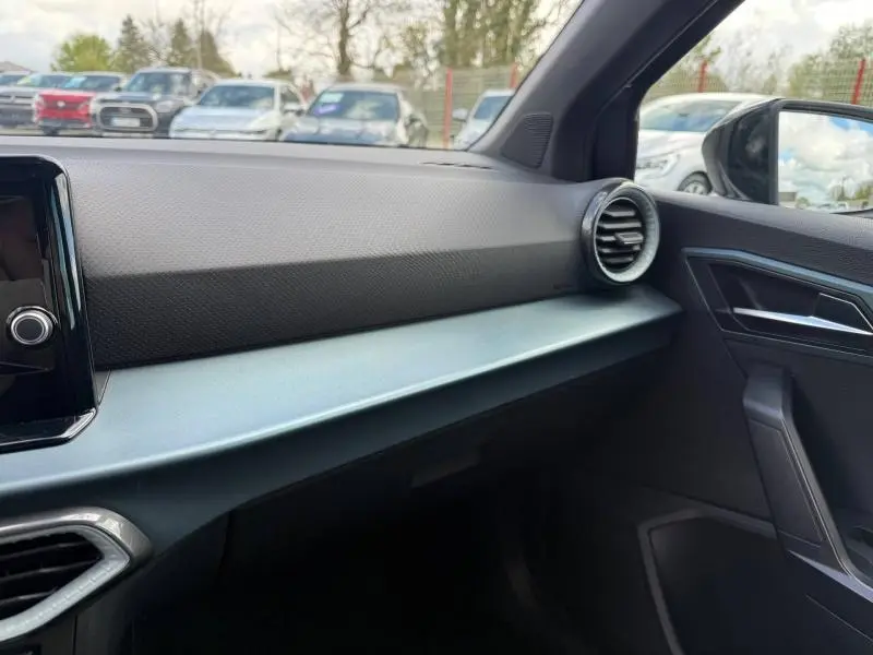 Intérieur côté passager du SEAT Arona 2025 gris Magnétique Métal, avec tableau de bord épuré et sortie d’air ronde.