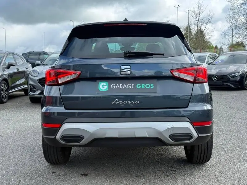 Vue arrière d'un SEAT Arona Gris Magnétique Métal 2025, avec feux arrière anguleux et double sortie d'échappement intégrée.