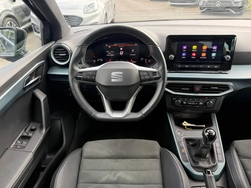 Vue intérieure centrée sur le volant et la console centrale du SEAT Arona 2025 avec boîte manuelle et écran tactile.