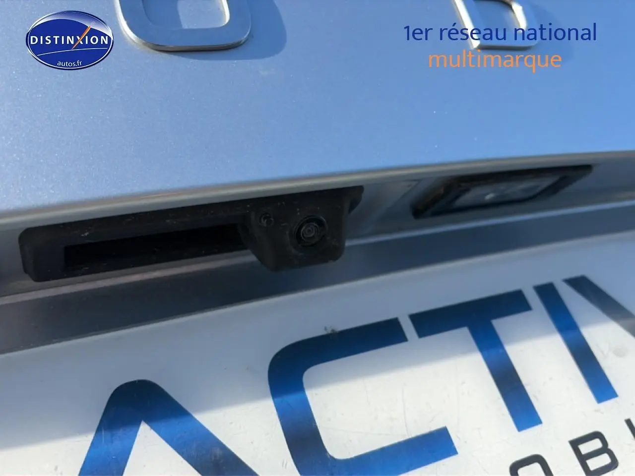 Gros plan sur la caméra de recul et la plaque d’immatriculation d’une Skoda Karoq gris clair.